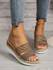 Detailansicht von Keilsandalen für Damen mit hohlen Webriemen und schöner Jutesohle.