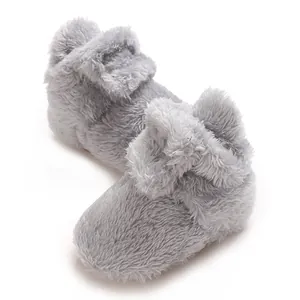 Detailaufnahme von weichen grauen Baby-Booties aus Korallenvlies mit flauschiger Textur.