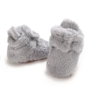 Detailansicht der weichen Textur von warmen, grauen Baby-Booties aus Korallenvlies
