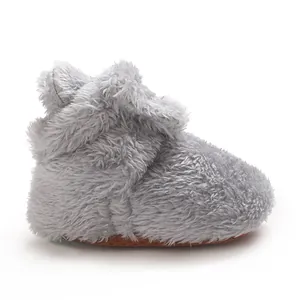 Grauer Babyhausschuh aus Korallenfleece mit warmer Fütterung und rutschfester Antirutschsohle.