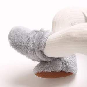 Nahaufnahme weicher grauer Korallenfleece-Babystiefel mit rutschfesten Sohlen und Wärme