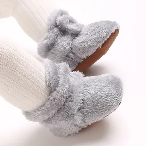 Nahaufnahme von grauen Korallenvlies-Babyschuhen mit Plüschtextur und rutschfester Sohle