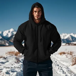 Men's solid black zip-up fleece lined hoodie shown in a scenic snowy mountain landscape.