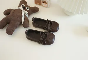 Nahaufnahme weicher brauner Leder-Ballerinas für Mädchen mit elastischen Riemen.