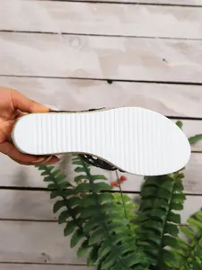 Detailansicht der weißen, rutschfesten Rillen-Außensohle einer Damen-Espadrille-Pantolette.
