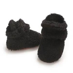 Detailansicht der schwarzen Baby-Schuhe aus Korallenvlies mit weicher Plüschstruktur.