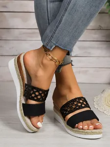 Detailansicht schwarzer gewebter Plateau-Keilsandalen mit Hanfseilsohle für Damen.