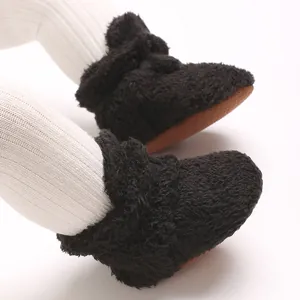 Nahaufnahme von weichen schwarzen Baby-Slippern aus Korallenvlies mit rutschfester Sohle