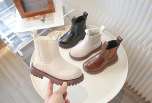 Detailed view of children's British style Chelsea boots in various colors on white table