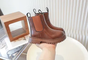 Close-up detail of children's brown leather Martin boots showing side elastic panels