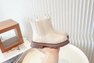 Close-up of cream children's Chelsea boots with brown platform lug soles