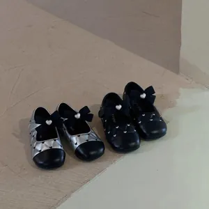 Detailed view of two pairs of quilted girls' Mary Jane shoes with chic bow accents