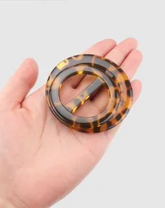 Close-up of high-end tortoiseshell resin decorative buckle for clothing details.