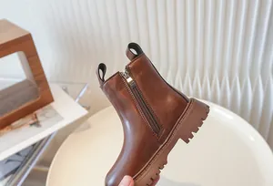 Close-up of brown children's British style Martin boot with side zipper and lug sole