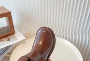 Close-up of brown retro children's Martin boot showing leather texture and stitching