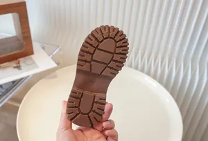 Detailed view of the non-slip brown rubber sole of a child's Martin boot.