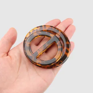 Set of two tortoiseshell resin decorative buckles for clothing accents in hand