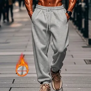 Close-up of men's grey fleece-lined joggers showing loose fit and drawstring waist