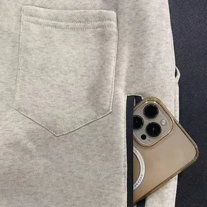 Close-up of men's fleece joggers featuring a zippered pocket and patch pocket detail