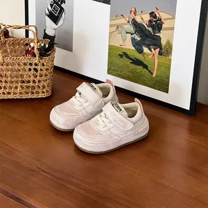 Gros plan de baskets rose et blanc pour tout-petits avec bandes velcro sur une table