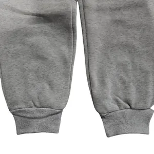 Close-up detail of the elastic ribbed ankle cuffs on grey men's fleece sweatpants