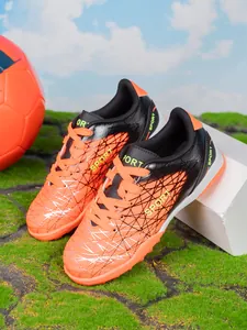 Professional orange and black kids turf soccer shoes with textured upper design