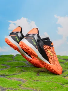 Side view of boys' TF turf soccer shoes showing orange studs and black leather upper