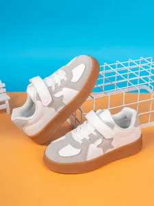 Close-up detail of children's low-top sneakers featuring grey star design and durable gum soles