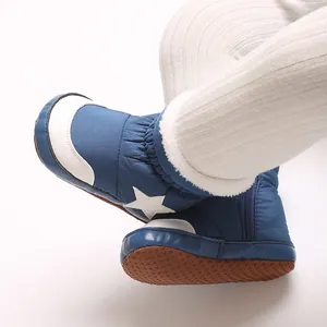 Détail de bottes d'hiver bleues pour bébé avec étoile blanche et doublure en fourrure.