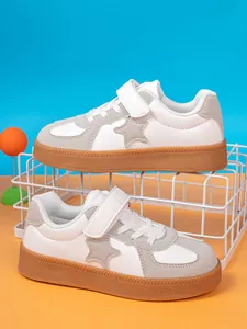 Side view of white and grey boys sneakers featuring star detail and durable gum soles