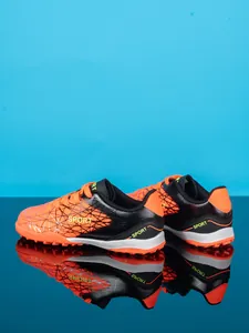 Professional kids turf soccer shoes in vibrant orange and black with sport prints