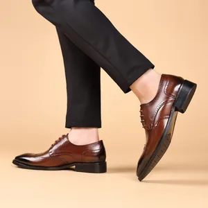 Stijlvolle bruine brogue herenschoenen van leer, zijaanzicht op het model getoond.