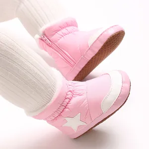 Gros plan sur des bottes de neige roses pour bébé avec étoile blanche et zip