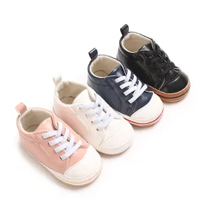 Groep baby wandelschoenen van PU-leer in roze, wit, marineblauw en zwart kleuren.