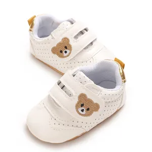 Detalle de zapatos para caminar para bebé blancos con bordado de oso y velcro