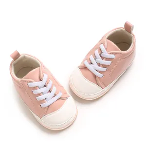 Detailoverzicht van roze PU-leren babysneakers met witte neus en zachte veters