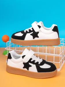 Boys' stylish casual low-top board shoes with star patch and gum sole on display stand