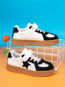 Detailed view of children's black and white skate shoes with gum sole and star patch