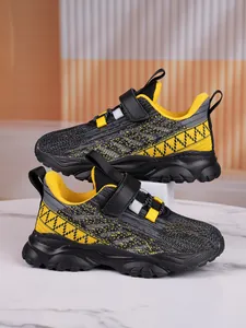 Detail view of breathable mesh children sneakers in grey and yellow with velcro straps.