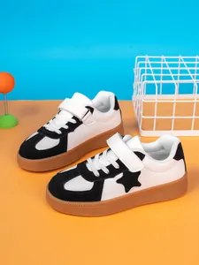 Detail view of boys' black and white board shoes with star pattern and gum sole
