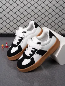 Vista detallada de zapatillas informales para niños en blanco y negro con suela de goma robusta