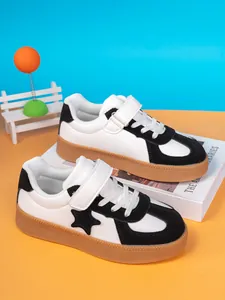 Detail view of boys' black and white skate shoes with star design and gum sole