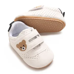 Primer plano de zapatos blancos para caminar de bebé en cuero sintético con bordado