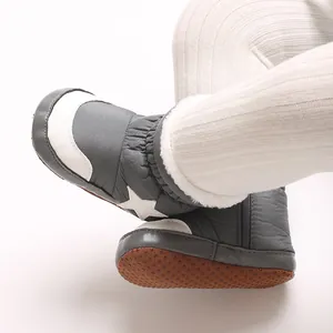 Détail de bottines d'hiver grises pour bébé avec motif étoile et bordure en fourrure.