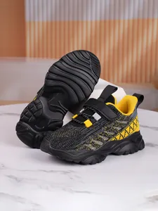 Detail view of breathable children's sneakers with non-slip soles in yellow and black