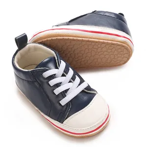 Detailopname van marineblauwe baby-sneakers van PU-leer met antislip rubberen zool.