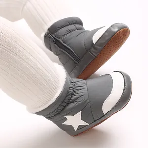 Gros plan sur des bottes d'hiver pour bébé grises avec motif étoile et doublure chaude