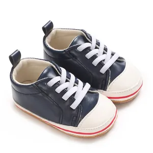 Zijaanzicht detail van marineblauwe PU-leren babysneakers met witte veters en zachte rubberzool