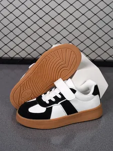 Vista detallada de zapatillas de skate blancas y negras para niños con suela de goma