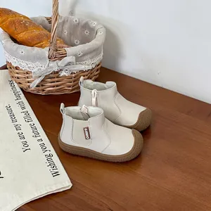 Soft-sole beige baby Martin boots displayed in a cozy rustic lifestyle setting